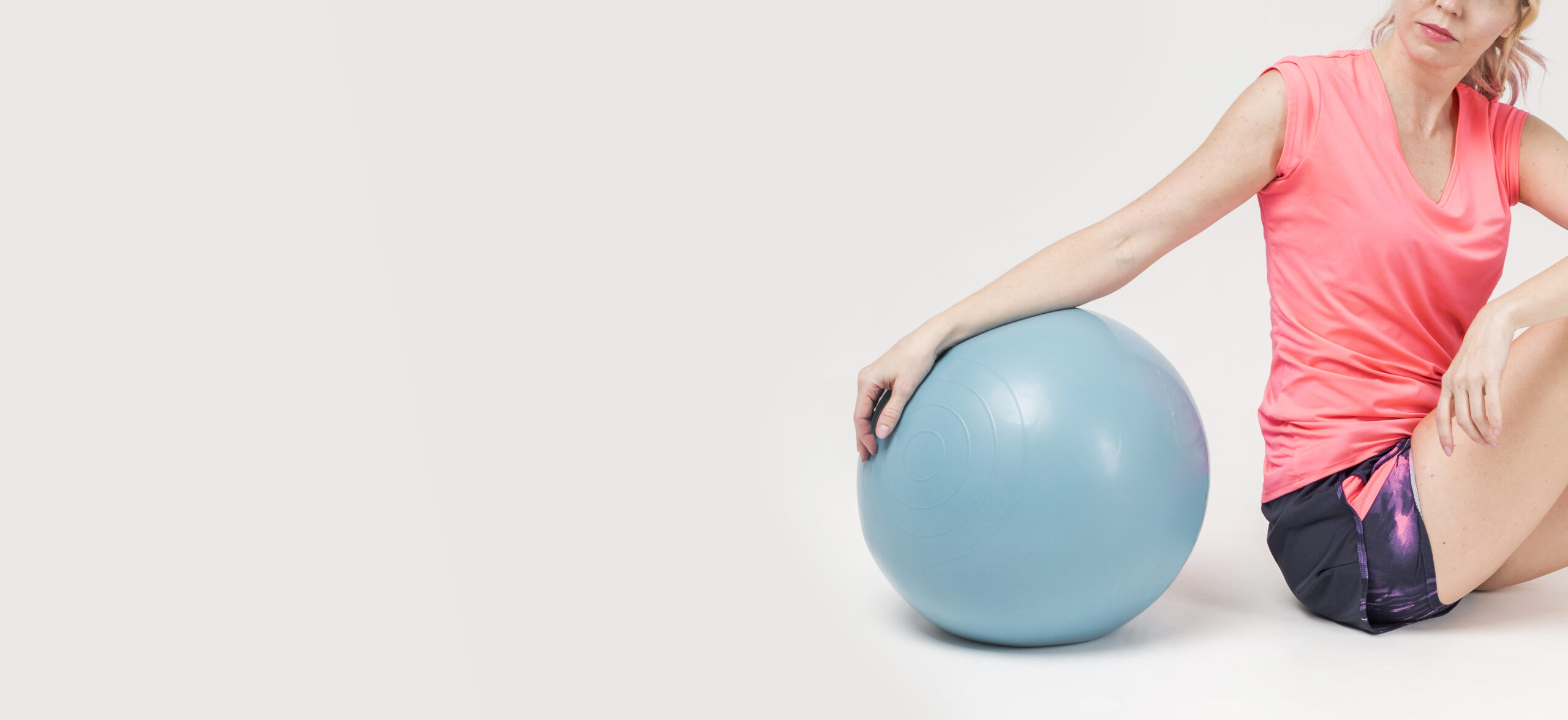 vista-lateral-de-la-mujer-posando-con-pelota-de-ejercicios-y-copia-espacio